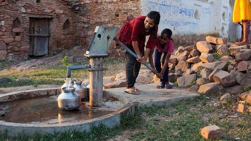 Jetzt spenden für Wasser und Hygiene! Bild: Mädchen pumpen Wasser aus einer Handpumpe.