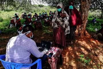 Corona-Hilfen: Menschen in Somalia registrieren sich für E-Gutscheine, mit denen Sie über ihr Handy bei ortsansässigen Händlern Saatgut oder Werkzeug kaufen können. 