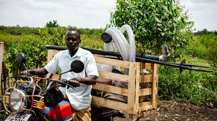 2021-agrishare-fischzucht-equipment-moped-uganda_C_welthungerhilfe.jpg Ein Bauer in Uganda auf einem Moped, 2021.