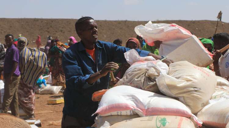 Hungerkrise am Horn von Afrika Ein Mann verteilt Hilfspakete an umstehende Menschen