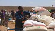 Hungerkrise am Horn von Afrika Ein Mann verteilt Hilfspakete an umstehende Menschen