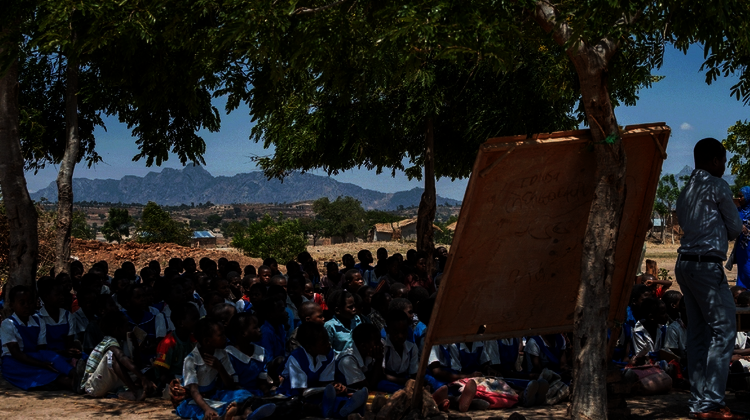 2019-gesundheitsclubs-kinder-training-malawi-lycka-welthungerhilfe.png Kinder sitzen auf dem Boden und hören zu.