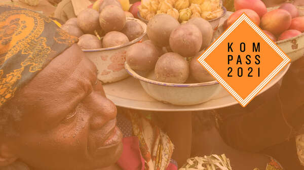 Verkauf auf einem Markt im Kongo: Frauen halten Tabletts mit Obst in die Höhe. Oben rechts ist das "Kompass 2021"-Logo.