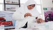 2021-safran-frauen-afghanistan-c-IlirTsouko.jpg Eine Frau hält eine Pinzette mit Safran. In der anderen Hand hält sie ein Glas.