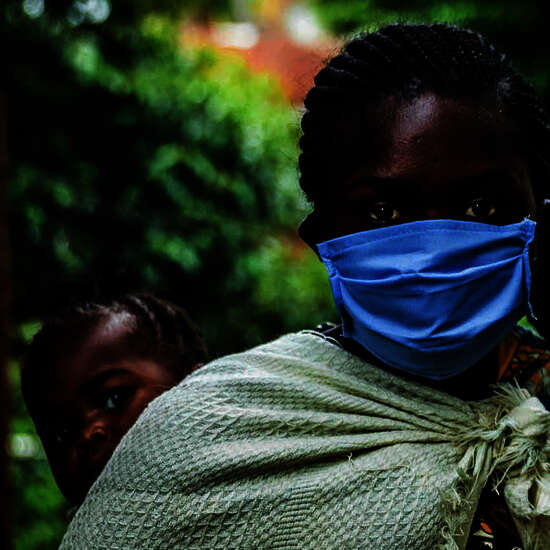 Coronavirus in Afrika. Bild: Eine Frau mit Mundschutz un einem Kind auf dem Arm.