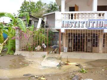Aufräumarbeiten auf Haiti durch Hurrikan Matthew © Welthungerhilfe Mann und Kind versuchen mit Eimern Wasser aus ihrem Haus zu bekommen