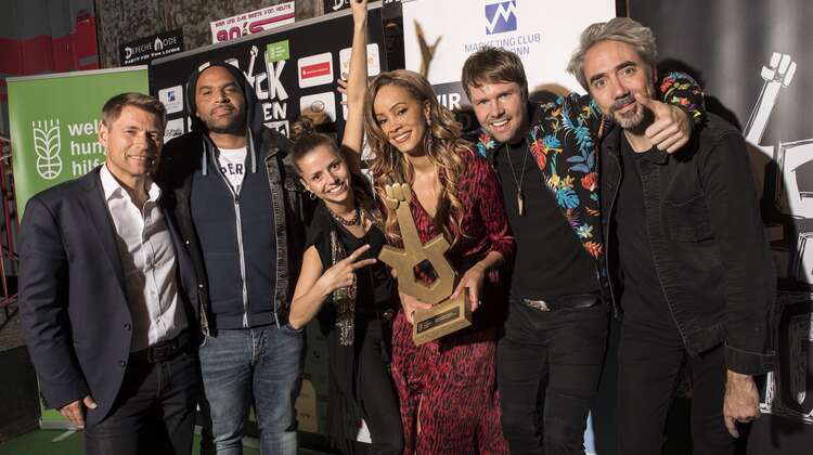 Rock gegen Hunger 2019: Gruppenfoto mit dem Logo des Marketing Clubs Köln-Bonn im Hintergrund. Rock gegen Hunger 2019: Gruppenfoto mit dem Logo des Marketing Clubs Köln-Bonn im Hintergrund.