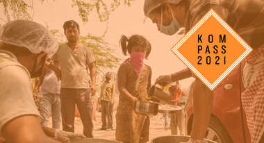 Corona-Krise in Indien. Ein Mädchen mit Mund-Nase-Schutz hält einen Teller und einen Topf, in welchen ein Mann Essen füllt. Oben rechts ist das Kompass 2021 Logo.