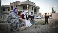 Jesidische Flüchtlinge sitzen vor einem Haus Jesidische Fluechtlinge im Nordirak Yazidi refugees in Northern Iraq