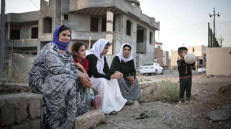 Jesidische Flüchtlinge sitzen vor einem Haus Jesidische Fluechtlinge im Nordirak Yazidi refugees in Northern Iraq