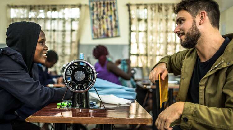 2018-prominente-robert-redweik-frau-naehmaschine-skillup-kenia-natalia-jidovanu.jpg Robert Redweik mit einer Frau vor einer Nähmaschine während eines Besuchs des "Skill up!"-Projekts in Nairobi, Kenia.