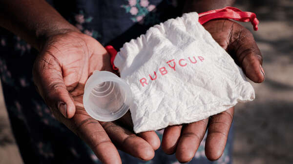 Eine Frau hält eine Menstruationstasse in der Hand, Südsudan 2022. 