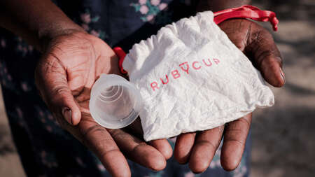 Eine Frau hält eine Menstruationstasse in der Hand, Südsudan 2022. 