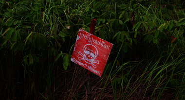 Ein rotes Schild mit einem Totenkopf darauf warnt vor Minen