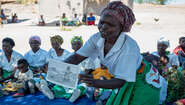 2019-community-health-club-malawi-lycka-welthungerhilfe.jpg Eine Frau hält ein Plakat in der Hand und erklärt.