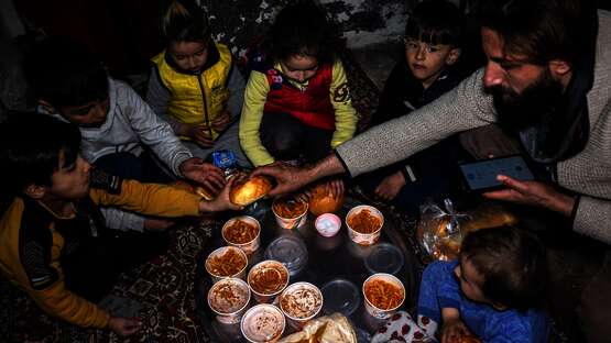 Eine Familie isst eine Mahlzeit der Suppenküche für Erdbebenopfer, Mardin/Türkei 2023.
