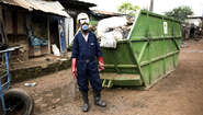 2019-abfall-management-sierra-leone-container_C_Kai-Loeffelbein-16-9.jpg Arbeiter in Schutzkleidung vor einem mit Müll gefüllten Container