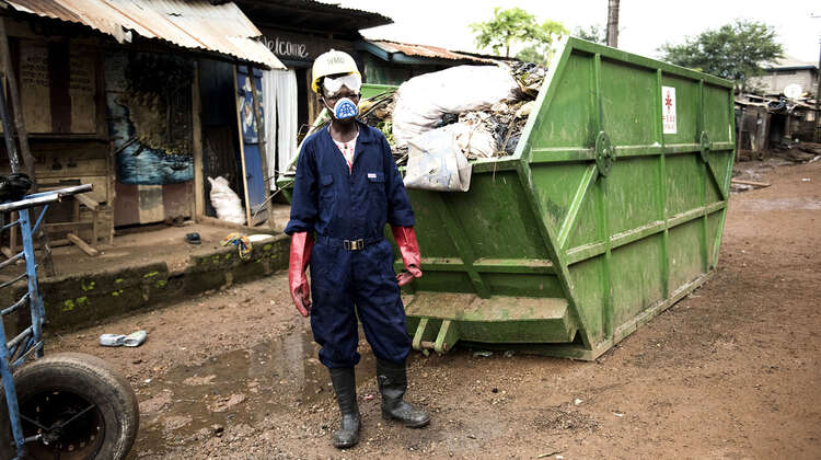 2019-abfall-management-sierra-leone-container_C_Kai-Loeffelbein-16-9.jpg Arbeiter in Schutzkleidung vor einem mit Müll gefüllten Container