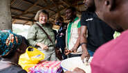 2019-marlehn-thieme-sierra-leone-schaukochen-lann_C_kai-loeffelbein.jpg Frauen und Männer lachen zusammen, man sieht eine Schüssel voller Essen.