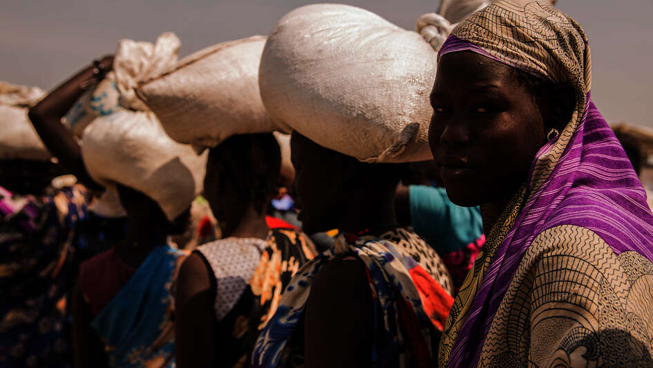 Hungersnöte verhindern. Bild: Frauen bei einer Lebensmittelverteilung im Flüchtlingscamp Bentiu.